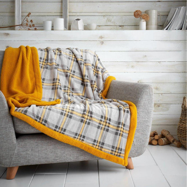 The HIGHLAND CHECK Sherpa Blanket is a great way to add contemporary class to your home furnishings. It features a striking grey and ochre color and a fluffy double Sherpa design, perfect for making a statement. Keep your space cozy and modern with this luxurious blanket.